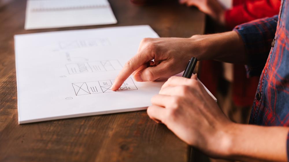 person pointing to a web wireframe