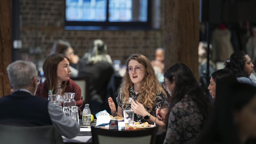Woman speaking to table of peers at the Great Digital for Good conference