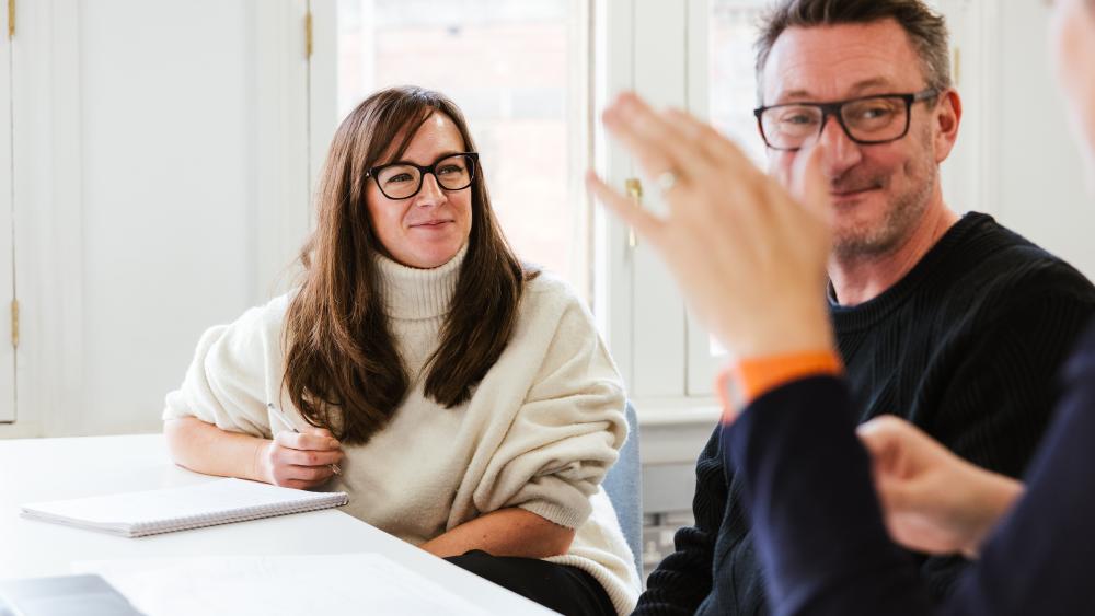 Two people engaged in conversation with a third person who is talking