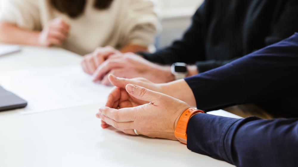 A focus on hands during a conversation between Numiko team members