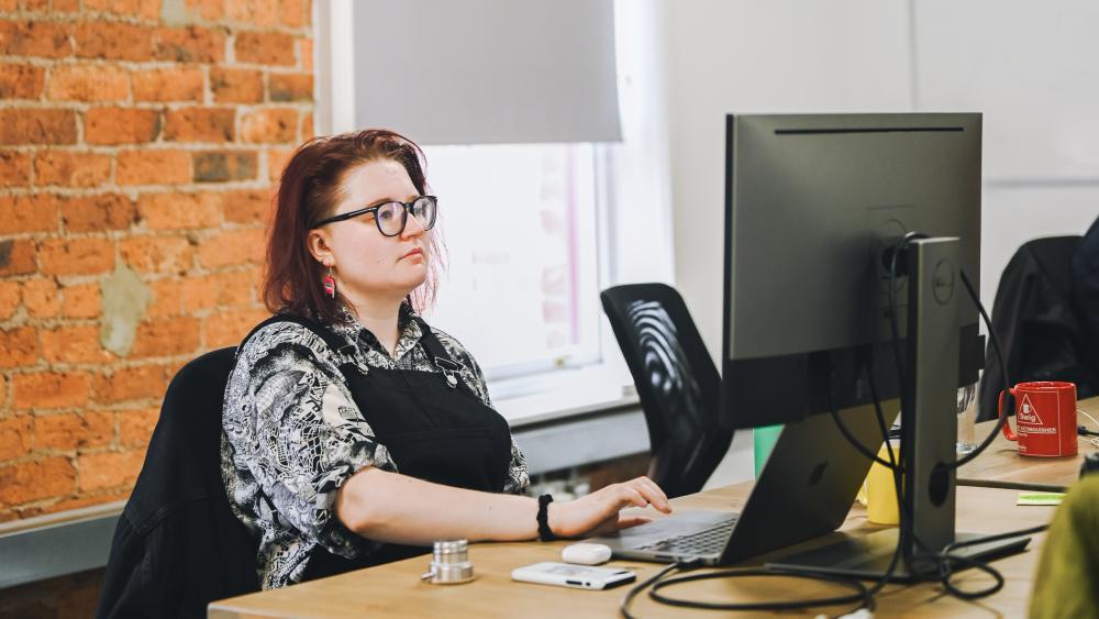 Soph working on a monitor at a desk in the Numiko office